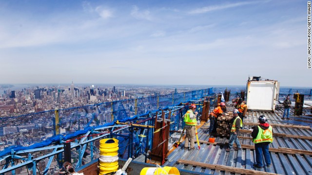 Ironworkers walk around the steel decking on the 100th story of the building on April 12, 2012.