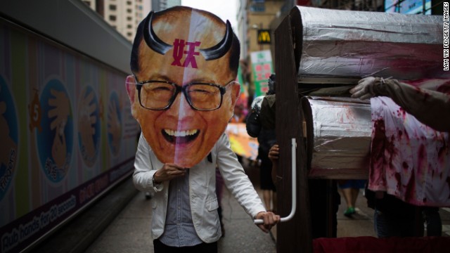 A protestor holds an oversized mask of billionaire tycoon Li Ka-shing, the chairman of Hutchison Whampoa, as hundreds of dock workers protest pay and working conditions in Hong Kong.