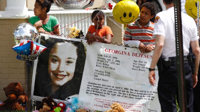 Children hold a sign and balloons in the yard of Gina DeJesus' family home in Cleveland on May 7.