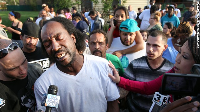 Neighbor Charles Ramsey talks to media as people congratulate him on helping the kidnapped women escape on Monday, May 6. He helped knock down the door after he heard screaming inside.