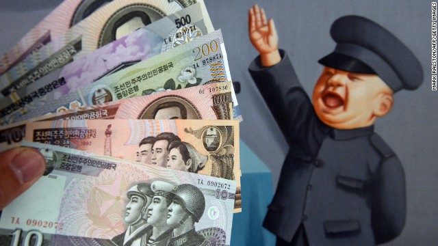North Korean currency purchased at a Chinese border town is displayed in front of a painting in Beijing.