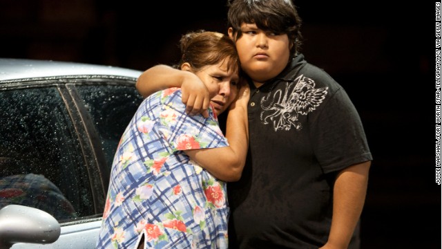 Eva Zapata, left, waits with family member Dario Segura for news of her children, who live in the Granbury, Texas, neighborhood of Rancho Brazos that was evacuated after storms on Wednesday, May 15, 2013. 