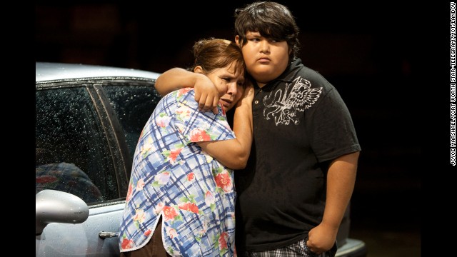 Eva Zapata, left, waits with a relative, Dario Segura, on May 15 for news of her children, who live in the Granbury neighborhood of Rancho Brazos. Six of the storm victims came from that subdivision, the Hood County sheriff said.