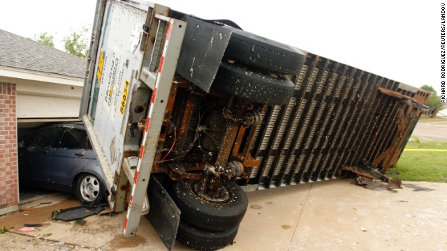 A trailer rests against a garage in Cleburne on May 16 after being blown into a house.