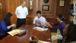 Berry President Steve Briggs presents graduating refugee students with silver engraved cups.