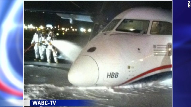 This image from WABC-TV shows emergency crews hosing down the plane with foam.