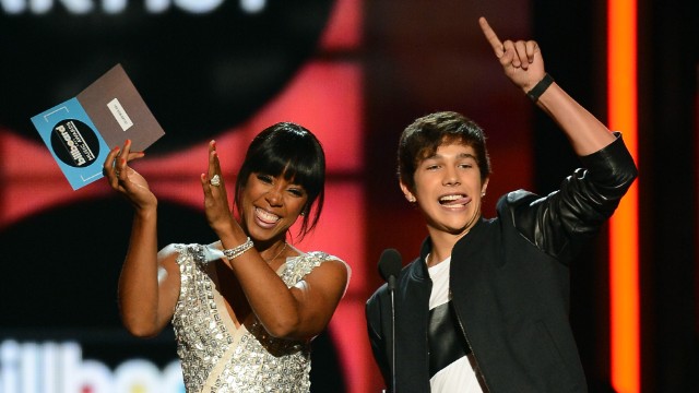 Presenters Kelly Rowland and Austin Mahone speak onstage.