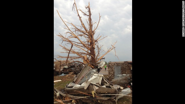 A shredded tree stands amid debris in the aftermath of the storm in Moore on May 20.