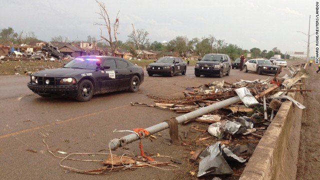 Law enforcement officers block a roadway in Moore where there was extensive damage from the tornado.