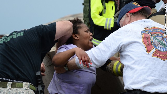 Rescue workers help free one of more than a dozen people who were trapped at a medical center in Moore on May 20.