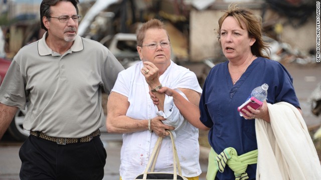 A woman with an arm injury is helped on May 20 in Moore.