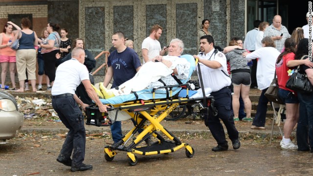 A man is taken away from the IMAX Theater in Moore that was used as a triage center on May 20.