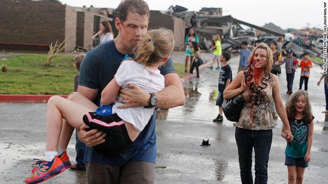 Teachers lead children away from Briarwood Elementary School on May 20. Read more about the photo.