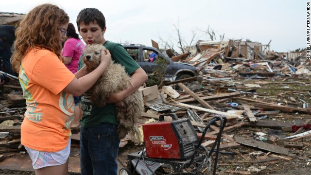 Abby Madi, left, and Peterson Zatterlee comfort Zatterlee's dog, Rippy, on Monday, May 20, in Moore.