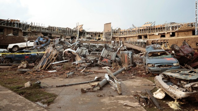 Cars marked with an orange X, meaning they have been checked for occupants, are piled up in front of the entrance to the damaged Moore Medical Center on May 20.