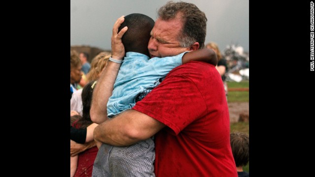 Jim Routon hugs his neighbor, 7-year-old Hezekiah, after the tornado strikes on May 20. An earlier version of this caption incorrectly stated that Routon was Hezekiah's teacher. See an interview with the pair. 