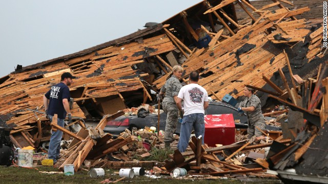 People sort through a leveled home in Moore on May 21.