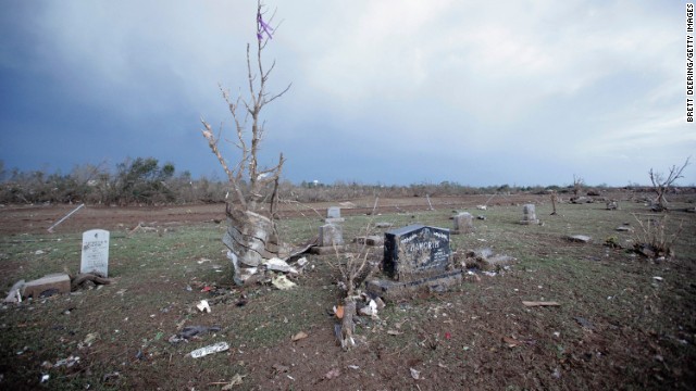 Headstones stand amid debris in the Moore Cemetery on May 21.