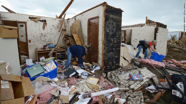 People recover belongings from the rubble of a home in Moore.