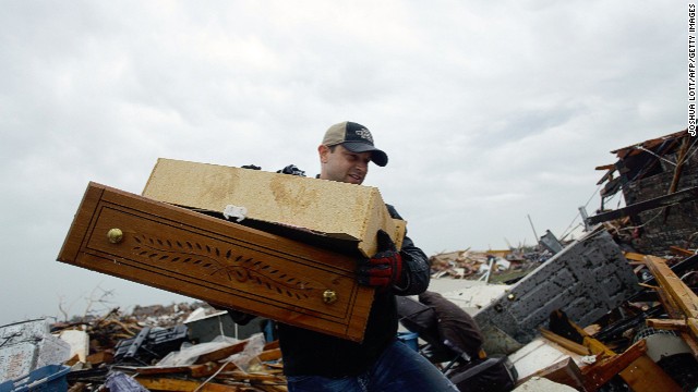 A man helps move a resident's belongings from a destroyed home on May 21 in Moore.