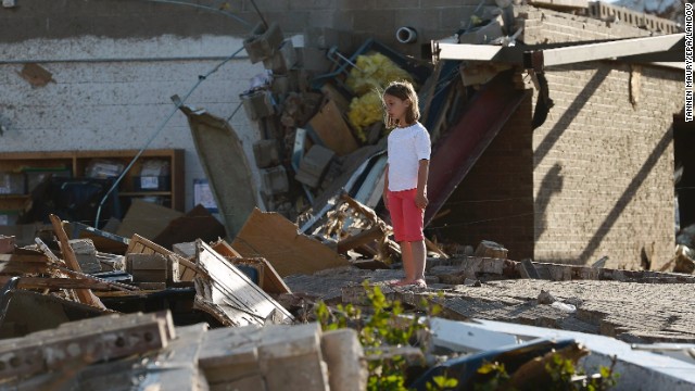 A young girl stands among the rubble outside Briarwood Elementary School on May 21.