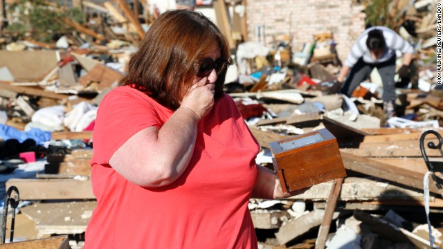 Kelli Kannady weeps after finding a box of photographs of her late husband in the rubble near where her home once stood in Moore on May 21.