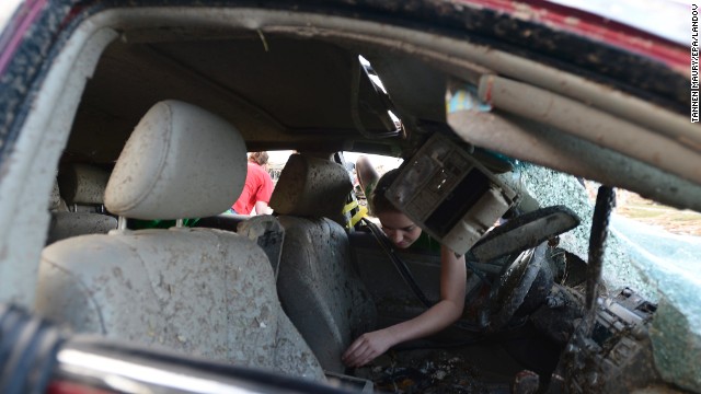 Natalie Johnson searches through her mother's destroyed car outside Briarwood Elementary School in Moore on May 21.