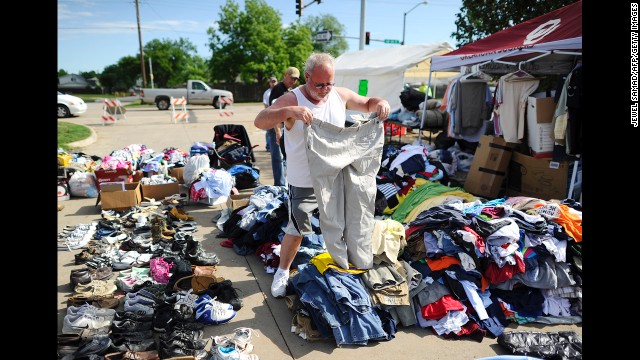 A man looks through a pile of clothing at a roadside relief camp on May 22 in Moore.