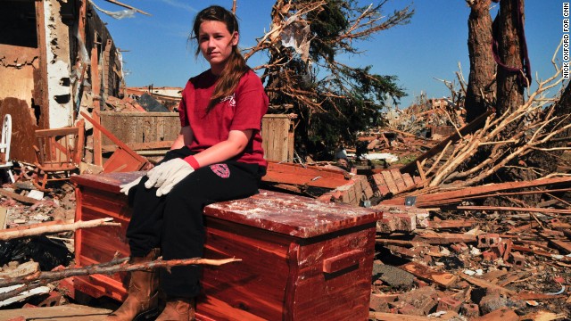 Payton Jo Lindsey sits on her grandmother's hope chest amid the ruins where her family's home once stood.