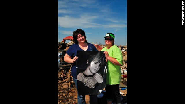 Jennifer Nutty-Marquez, left, and Jamie Plunk saved a poster of Nutty-Marquez's son, Caleb, from the wreckage of their home.