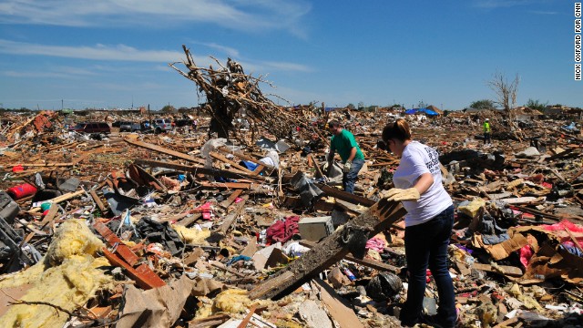 Jason Keen and his wife, Katy, search through the wreckage in a field of debris behind their house.