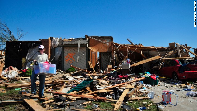 Jill Ashbaugh works to remove her family's recovered belongings from their home.