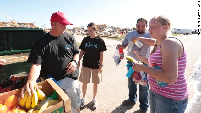 Travis French and his wife, Amy, of Capitol Hill Baptist Church hand out fresh fruit, water and hygiene packs to Thomas and Kelcy Trowbridge.