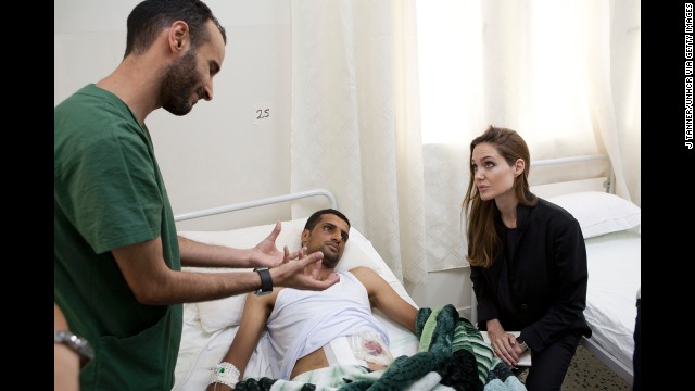 Jolie visits a man in a hospital in Misrata, Libya, on October 11, 2011, in this handout photo provided by UNHCR.