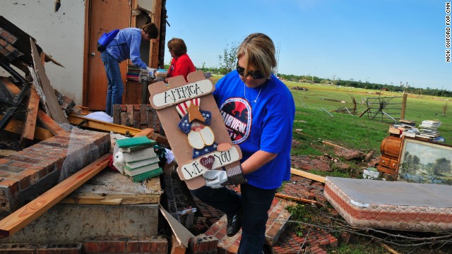 Lisa Brown helps her former colleague Kay Taylor pull belongings from the wreckage of her home. Taylor, a former PE teacher and school counselor, was most concerned about finding her collections of pennies, gumball machines and ladybug figures.