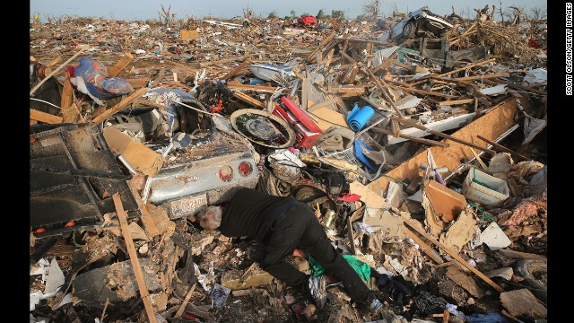 Mike Hitch prepares to pull a classic Corvette from under the debris of a home destroyed by Monday's tornado on May 25.