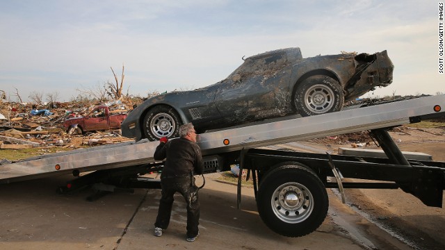 Mike Hitch loads a salvaged Corvette pulled from the rubble onto a tow truck in Moore on May 25.