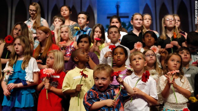 Preschooler Keltin Marazzi, front center, stands on stage with other school children during the memorial service. 