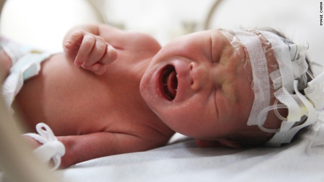 The newborn baby is pictured in the hospital after being rescued.