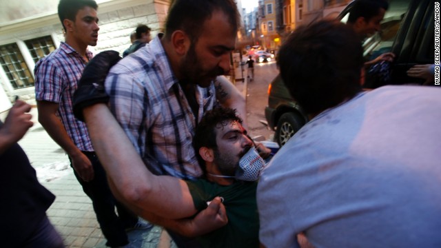 Friends carry an injured protester on May 31. More than a dozen people have been injured in the clashes.
