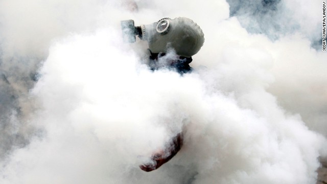 An activist wearing a gas mask is enveloped in a cloud of tear gas on May 31.