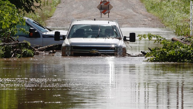 Two pickup trucks are pictured stuck in high water along North West 23rd Street in El Reno on June 1. Heavy rain has caused flooding in the area.