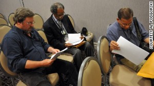 Photographers Tom Cruze, from left, John H. White and Brian Jackson look over paperwork during the mass layoff at the Chicago Sun-Times on May 30.