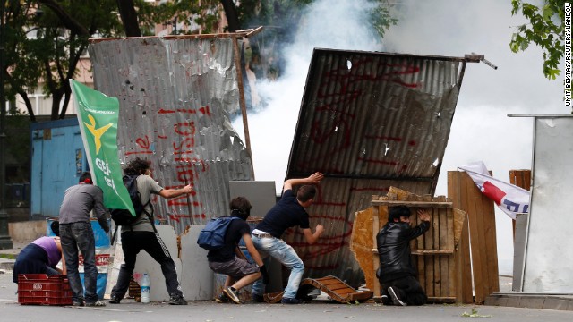 Demonstrators hide behind makeshift shields during clashes with Turkish riot police in Ankara on June 2.