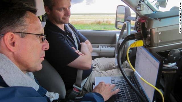 Tim Samaras and Carl Young read data. At a meteorological conference, Samaras encouraged Young to gather data from inside tornadoes for his thesis, and a partnership was born. 