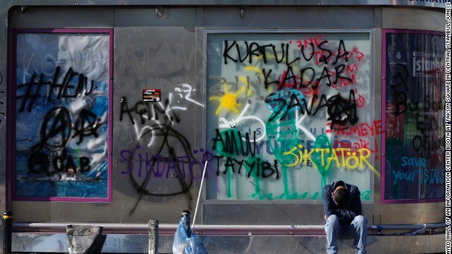 A tired protester rests in front of the graffiti-sprayed wall of an information booth at Taksim Square in central Istanbul on June 3.
