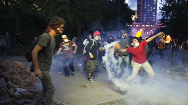Protesters throw riot police's tear gas back at them in Istanbul on June 3.