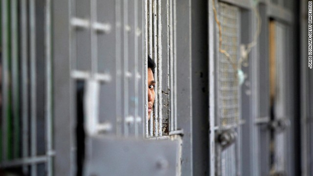 An inmate peers through the bars of a cell at the Federal District Penitentiary in Mexico City.