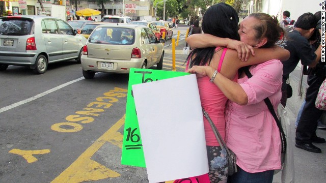 Family members of Jerzy Ortiz Ponce embrace one another while holding signs for the missing on May 31 in Mexico City.