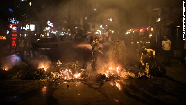A municipal worker collects garbage set on fire by Turkish protesters in a restaurant district of Ankara on June 5. 
